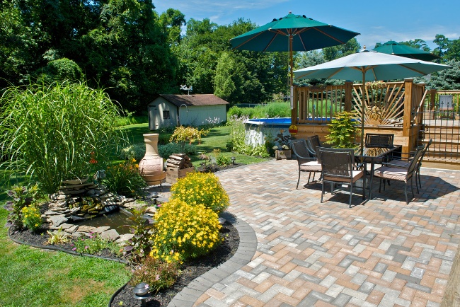 Affordable patio construction enhances outdoor living space with greenery and seating