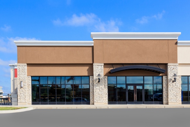 New commercial building under sunny sky showcasing modern architecture and expansive glass design