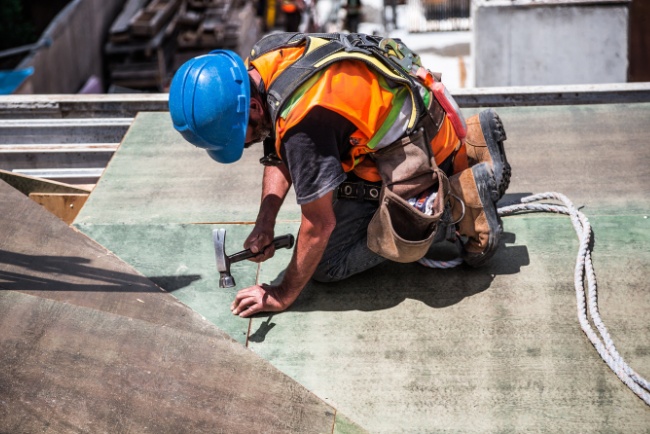 Commercial roofing services in action during daytime at a construction site