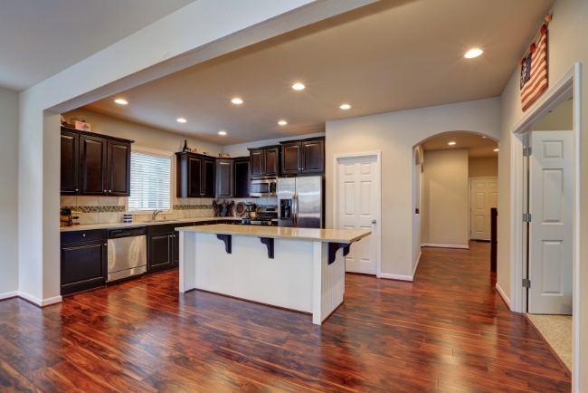 Custom kitchen remodeling showcasing modern design with dark cabinetry and polished wood flooring