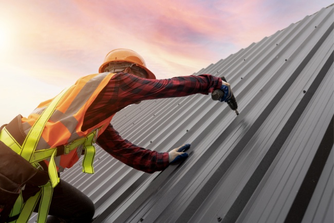 Roofers working on residential project during sunset in a suburban area