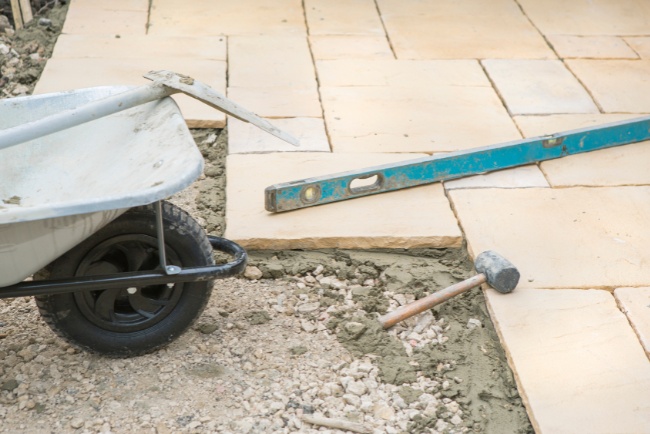 Innovative outdoor patio design in progress featuring natural stone paving and essential tools for installation