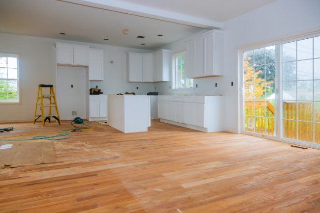 New kitchen remodeling project featuring wooden flooring and fresh cabinetry in a bright, open space