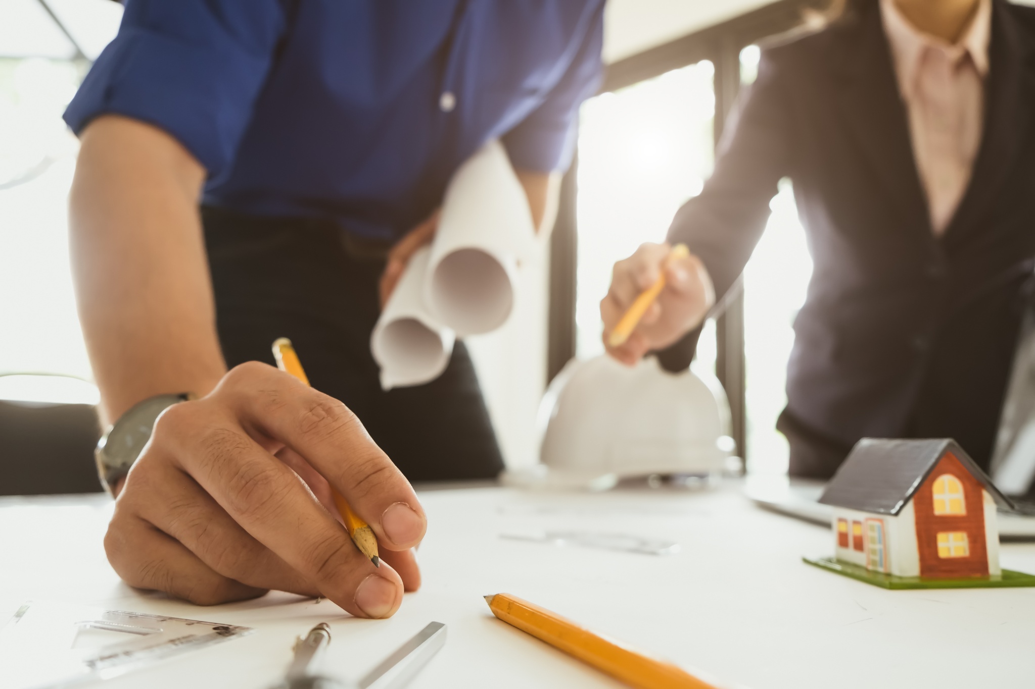 Residential contractors collaborate on design plans during a project meeting in a modern office space