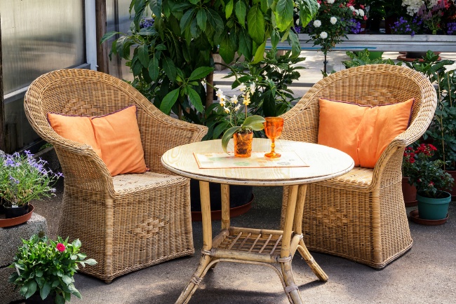 Relaxing patio space featuring wicker chairs and decorative plants in a residential setting