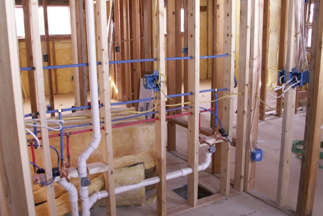 Retrofit project underway at construction site with scaffolding under clear blue sky